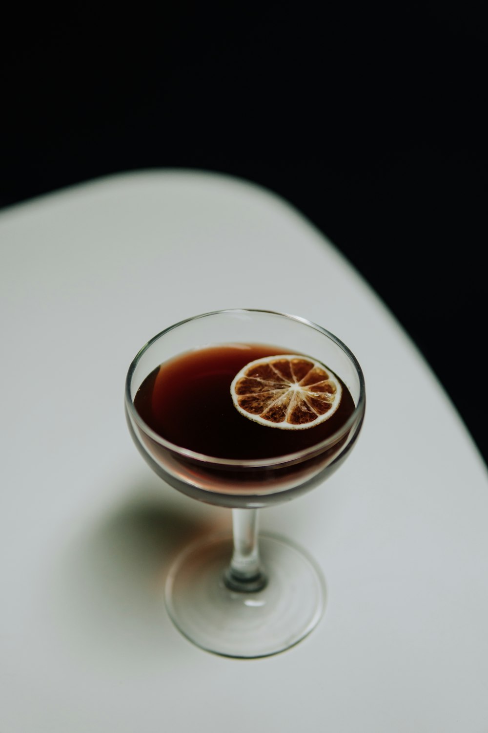 a glass filled with a liquid and a slice of orange