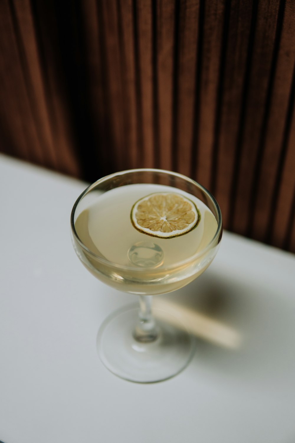 a glass filled with a drink sitting on top of a table