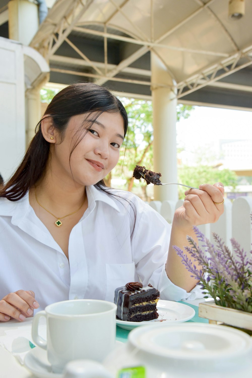 a woman sitting at a table eating a piece of cake