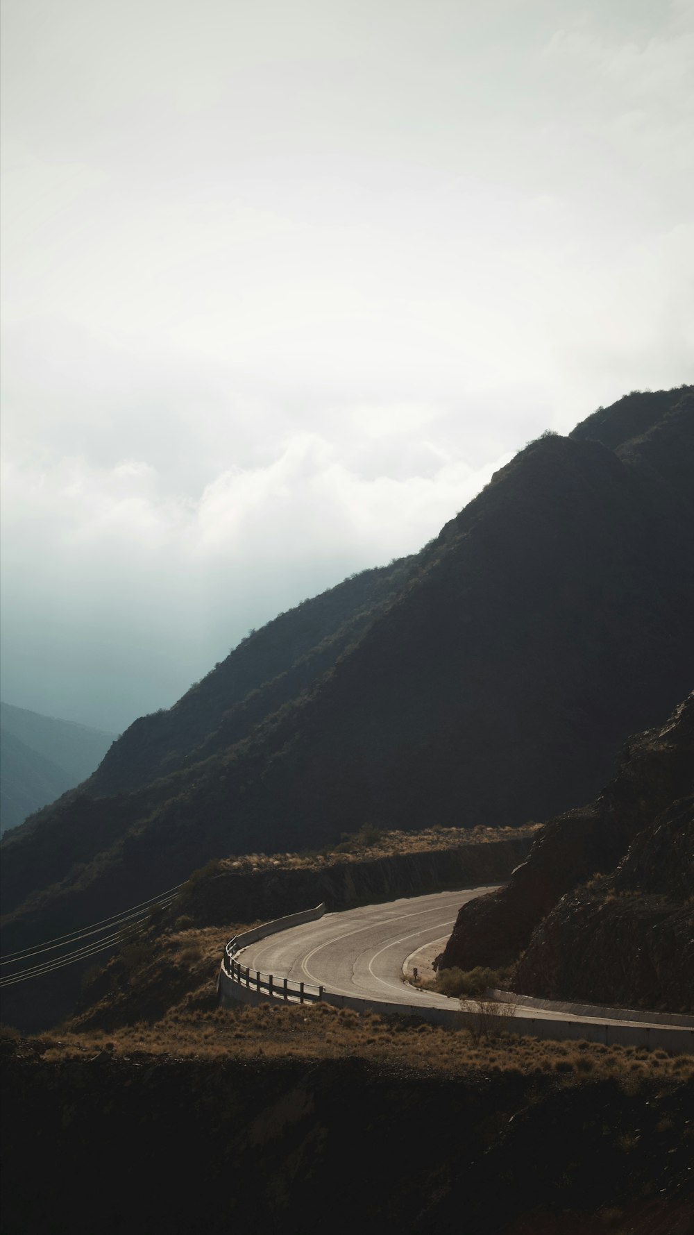 Una strada tortuosa in montagna in una giornata nuvolosa