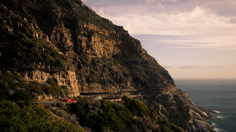 a car driving down a road next to a cliff