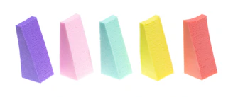 Close-up of colorful sponges and scrubbers stacked neatly in a basket.