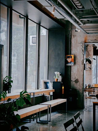 A sleek industrial workspace bathed in soft natural light, showcasing a blend of modern machinery and minimalist luxury furniture.