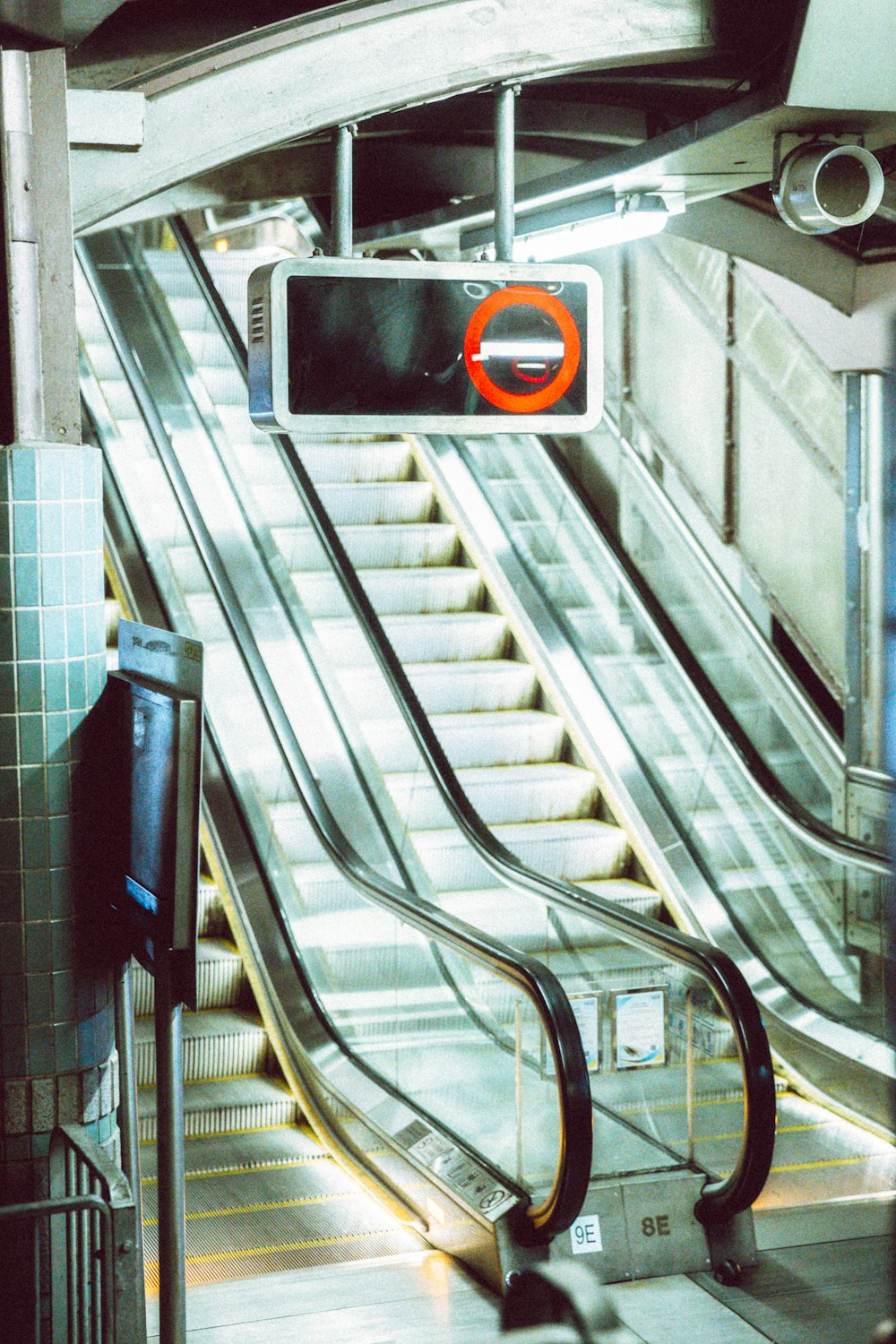 an escalator with a sign above it