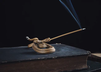 An ancient serpent coiled around a bronze staff, symbolizing wisdom and transformation.