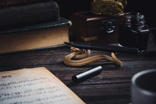 A vintage ink pen resting on aged parchment beside an old-fashioned mailbox.