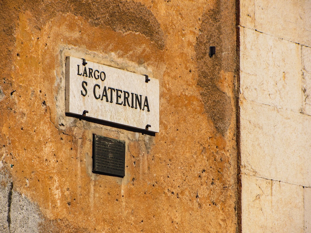 Un panneau sur le côté d’un bâtiment qui dit Largo S Caterina
