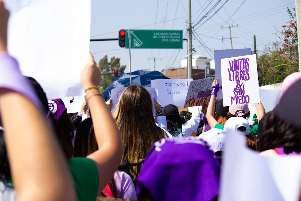 a group of people holding up signs in the street