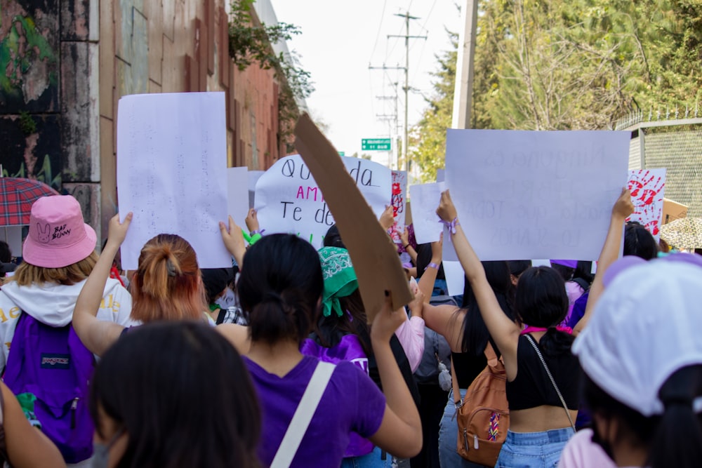 a group of people holding up signs in the street