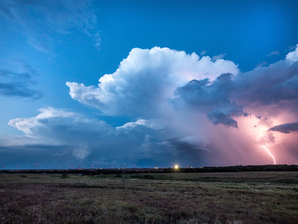 a large cloud filled with lightning in a blue sky