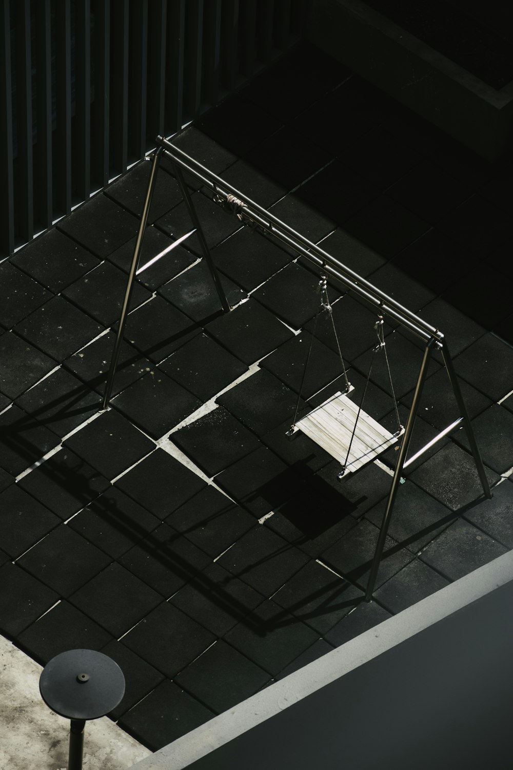 a white swing sitting on top of a black floor
