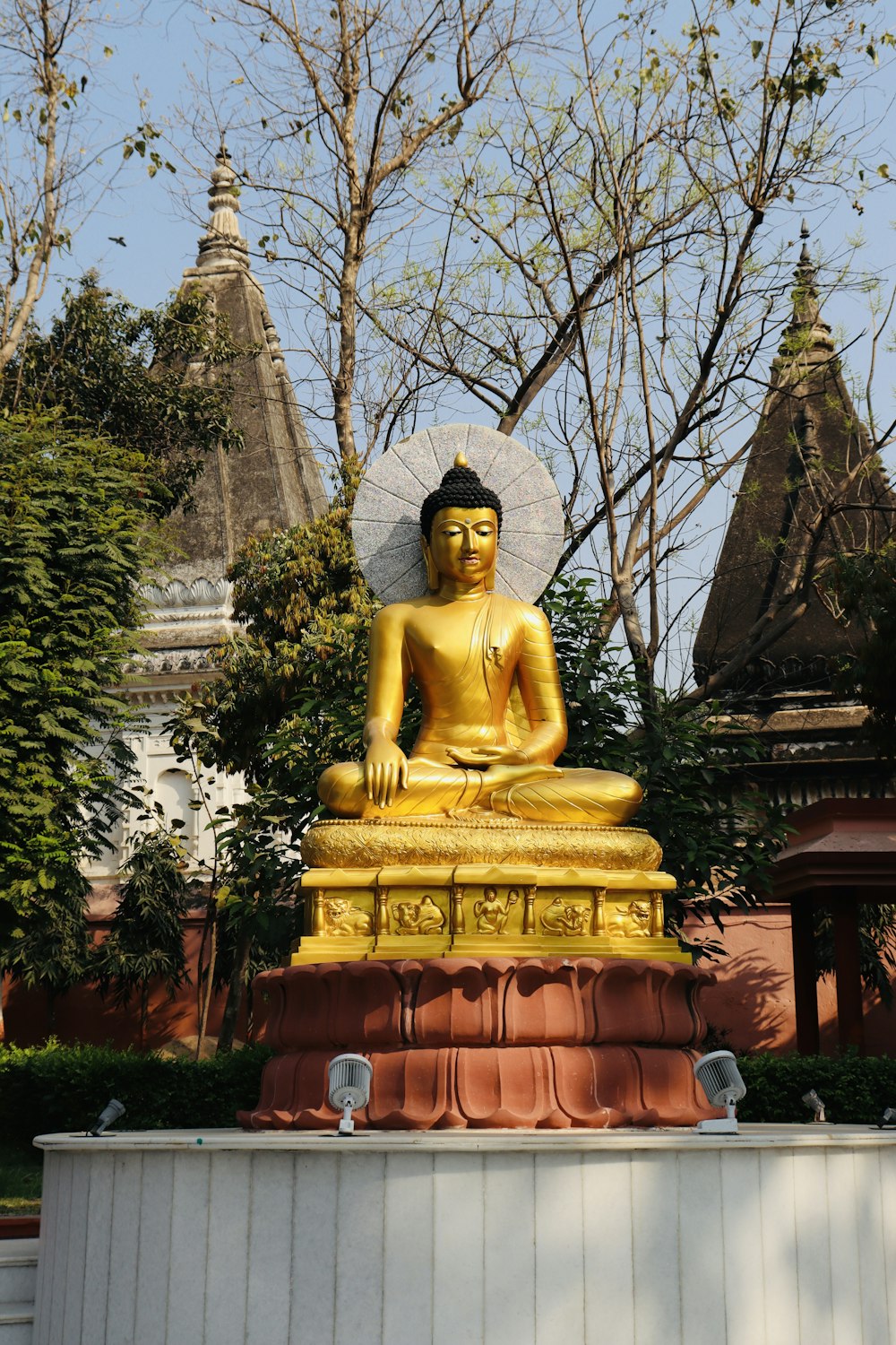 a golden buddha statue sitting in front of a building