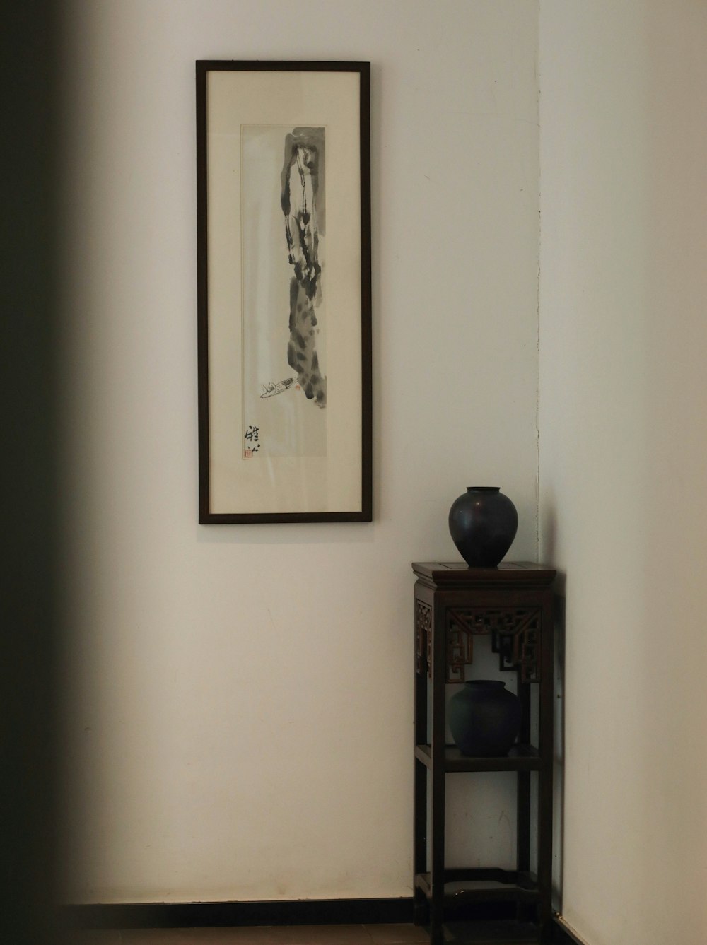 a black vase sitting on top of a wooden table