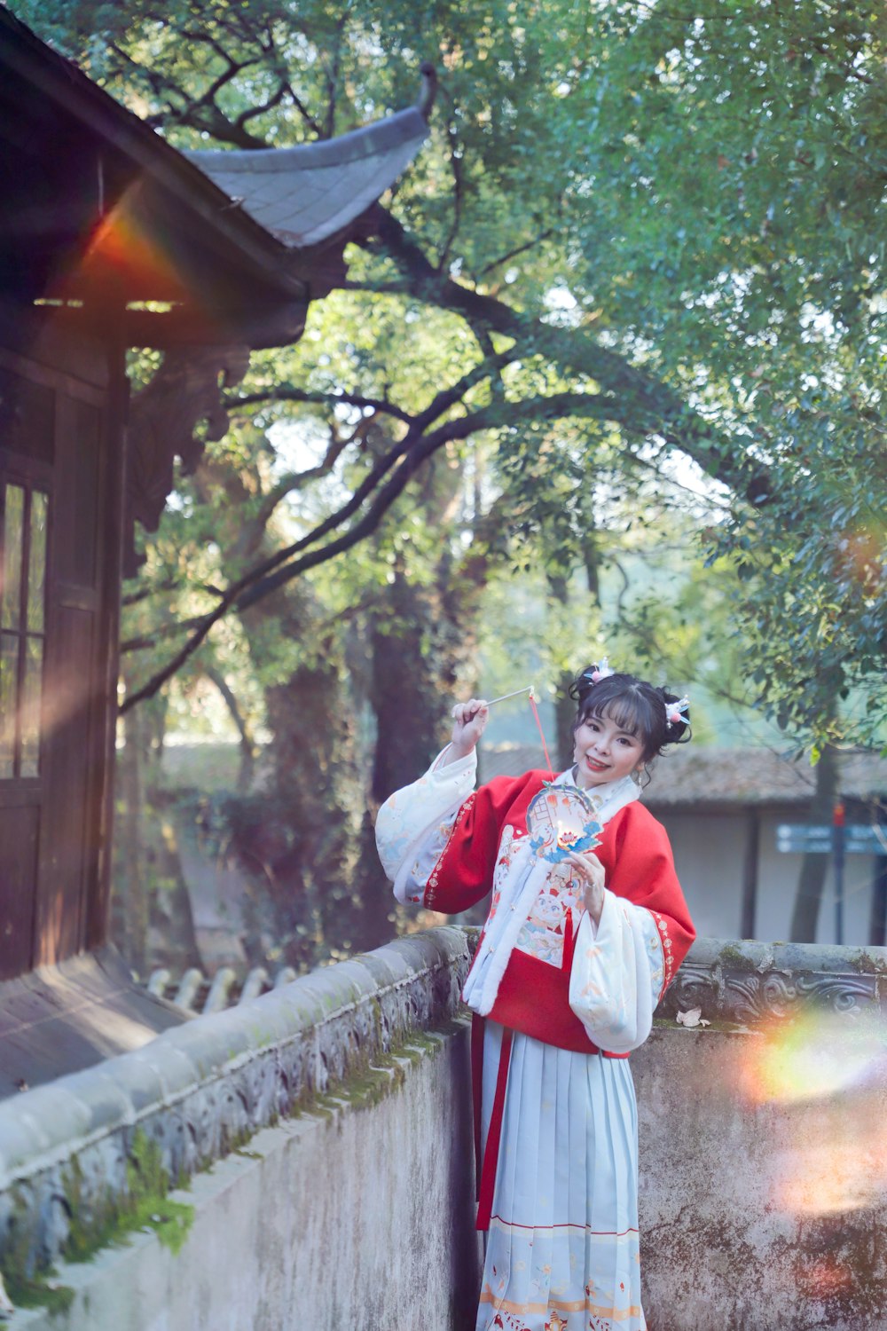 a woman in a red and white dress standing next to a tree