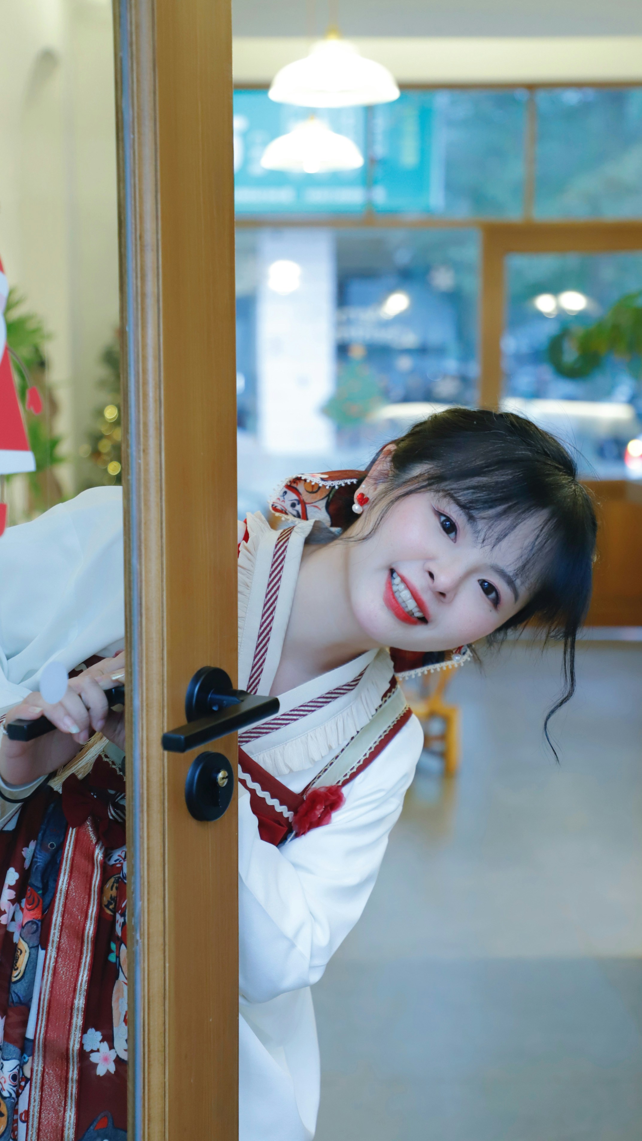 a woman in a traditional japanese dress holding onto a door handle