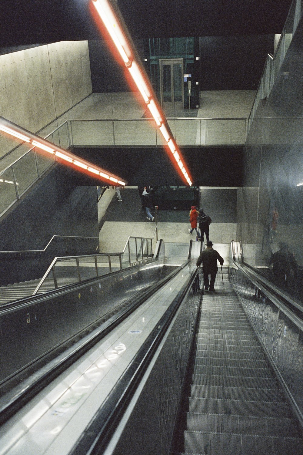 a group of people riding down an escalator