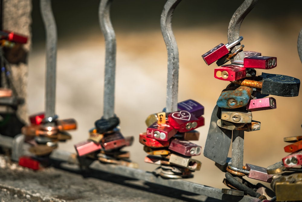 a row of colorful locks attached to a metal fence