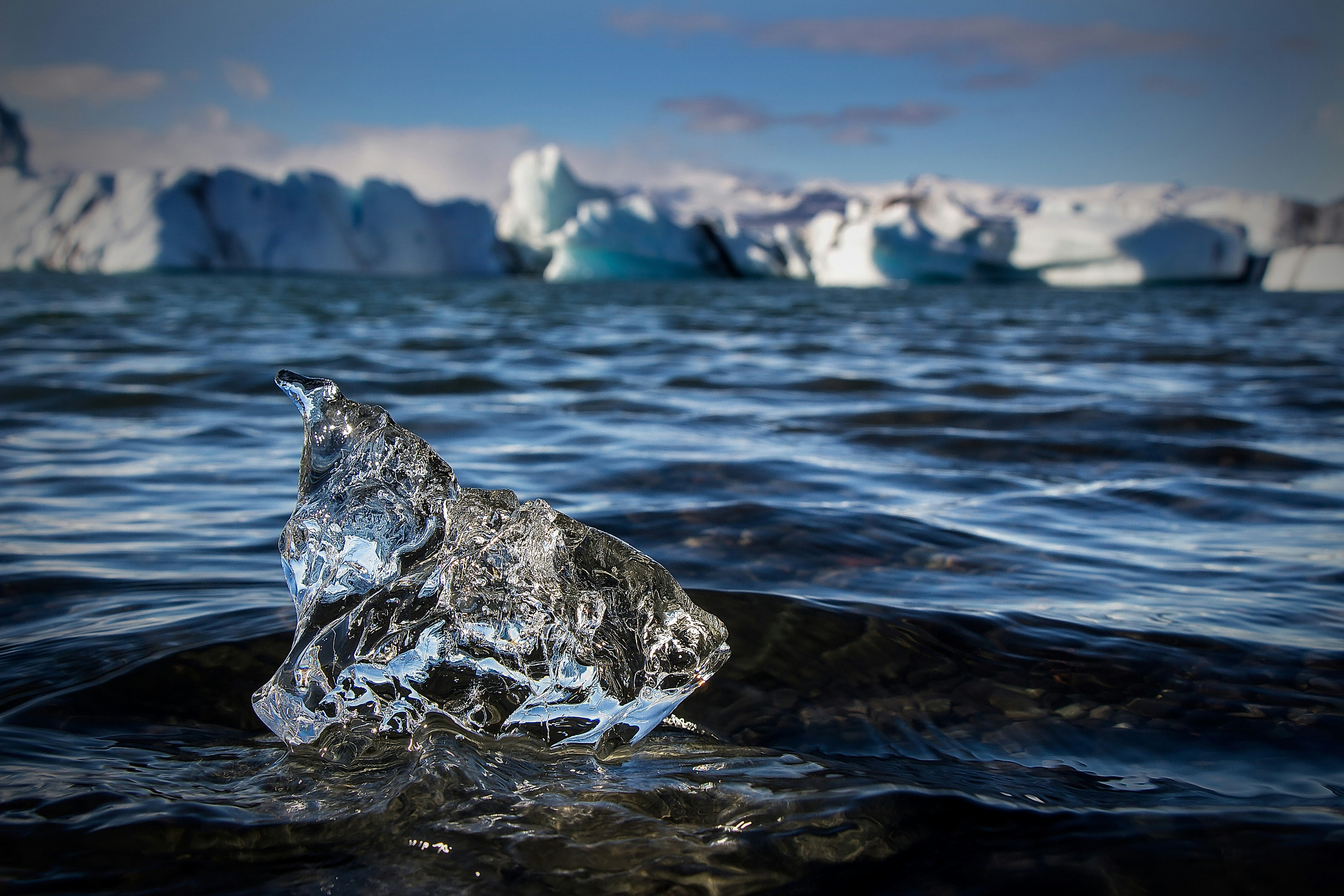 an iceberg floating in the water with icebergs in the background