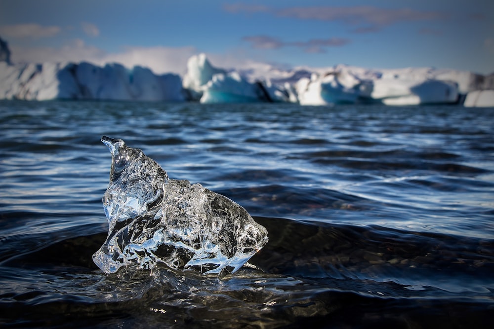 an iceberg floating in the water with icebergs in the background