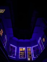 A dark-themed office interior illuminated by neon purple and green lights.
