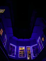 Spacious lounge area in the executive suite illuminated by smooth purple and blue neon lighting.