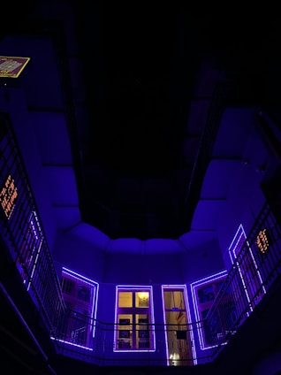A sleek, dark-themed office space featuring neon purple lights with a futuristic 3D holographic interface displaying social media analytics.