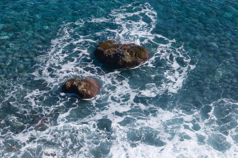 two rocks in the middle of a body of water