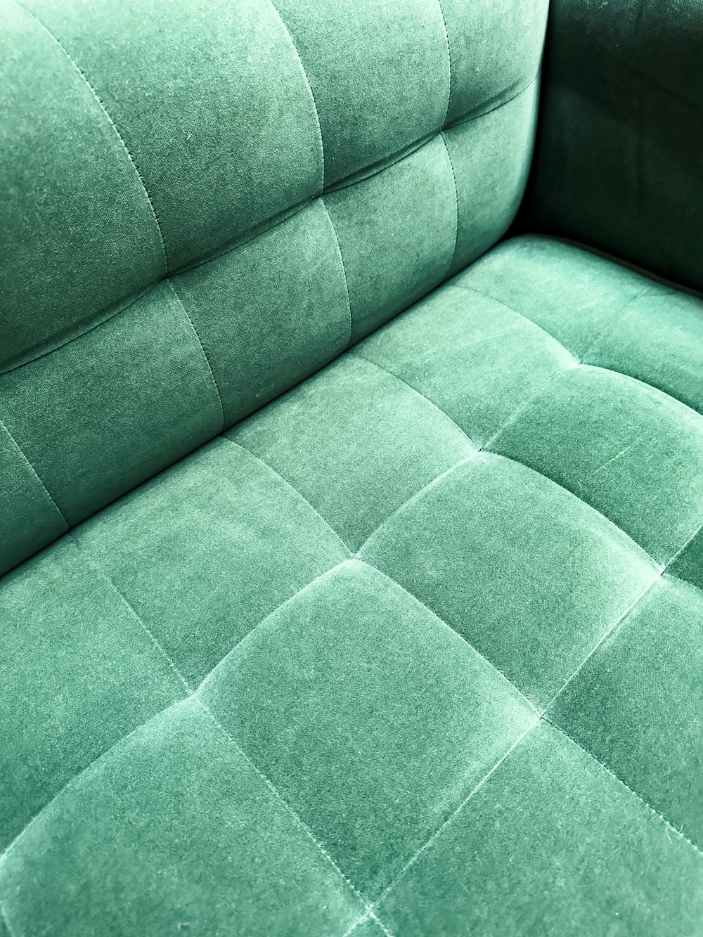 a close up of a green velvet couch