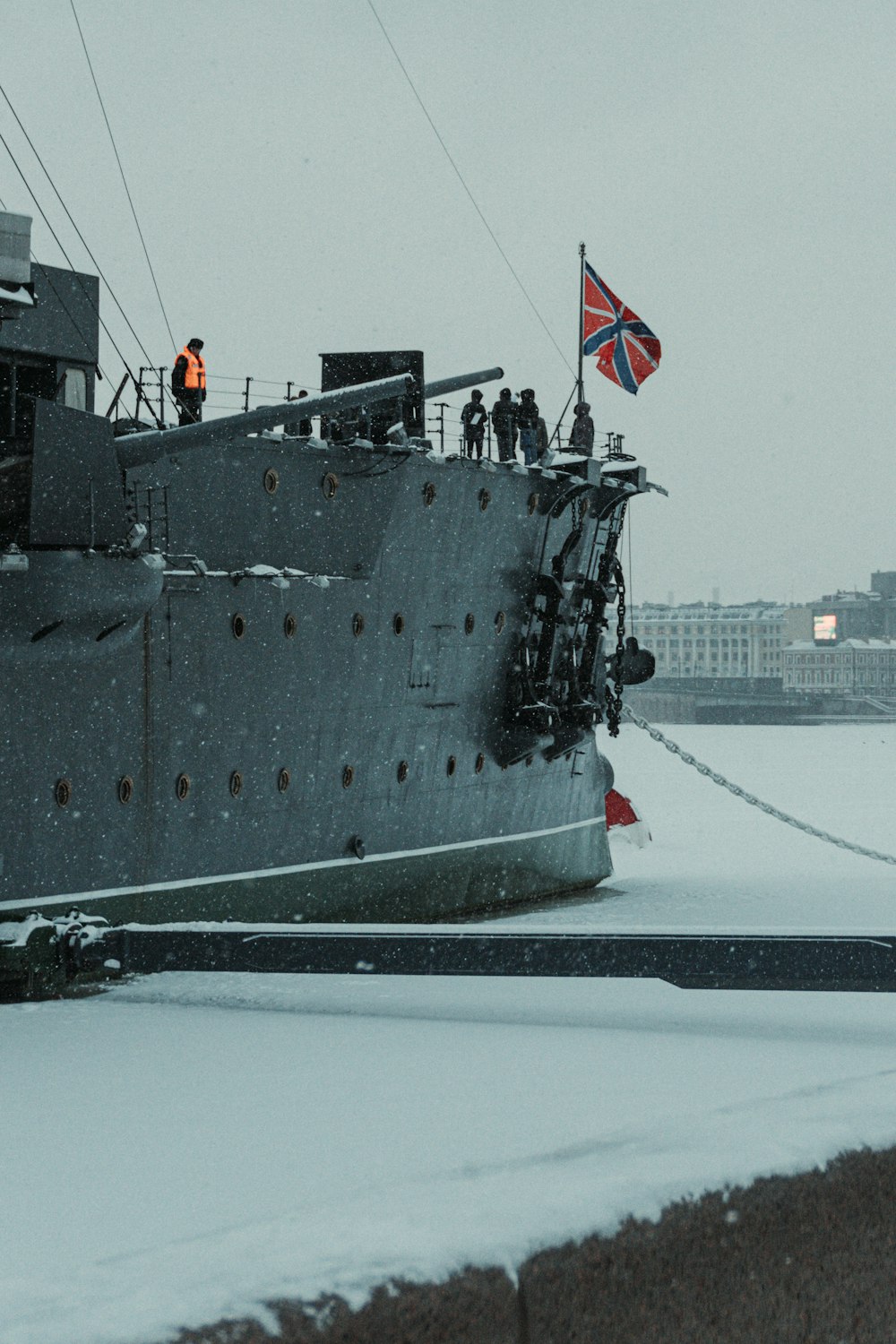 a large boat with a flag on top of it in the snow