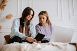 Two sisters working together on a laptop in a cozy office space