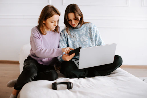 Young Mexican couple reviewing digital documents on a tablet at home with an urban city background.