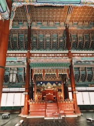 Royal throne room decorated with gold and red banners symbolizing power.