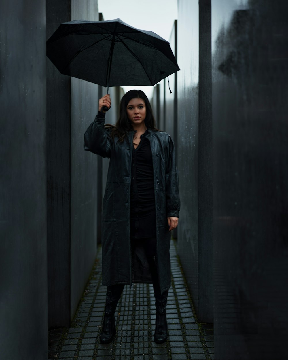 a woman standing in a hallway holding an umbrella