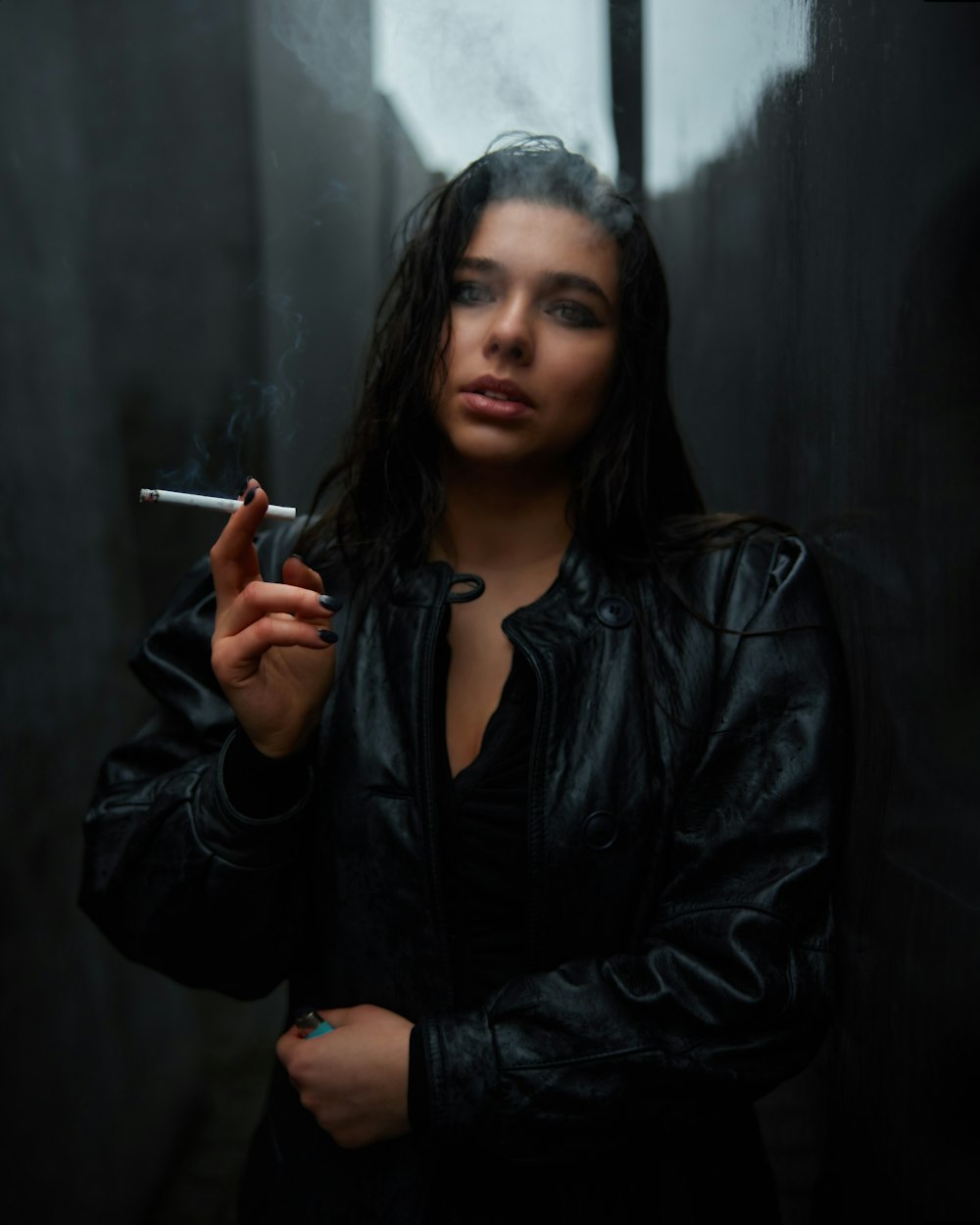 a woman smoking a cigarette in a dark room