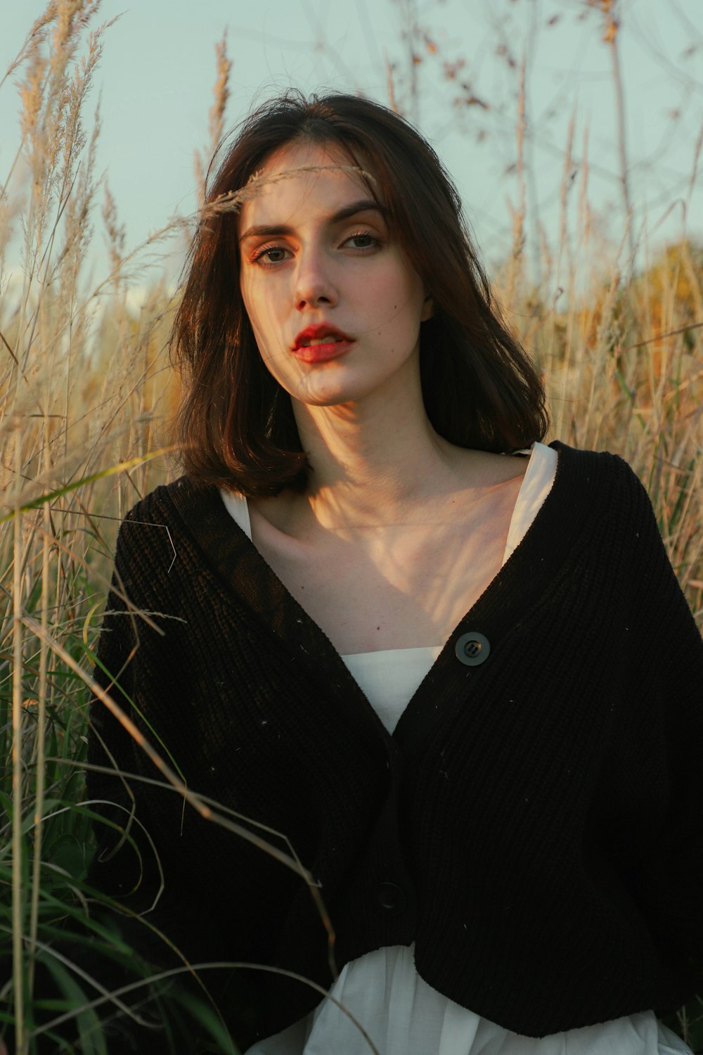 a woman standing in a field of tall grass