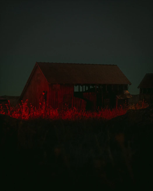 Dark and red themed industrial IoT devices monitoring livestock health in a barn