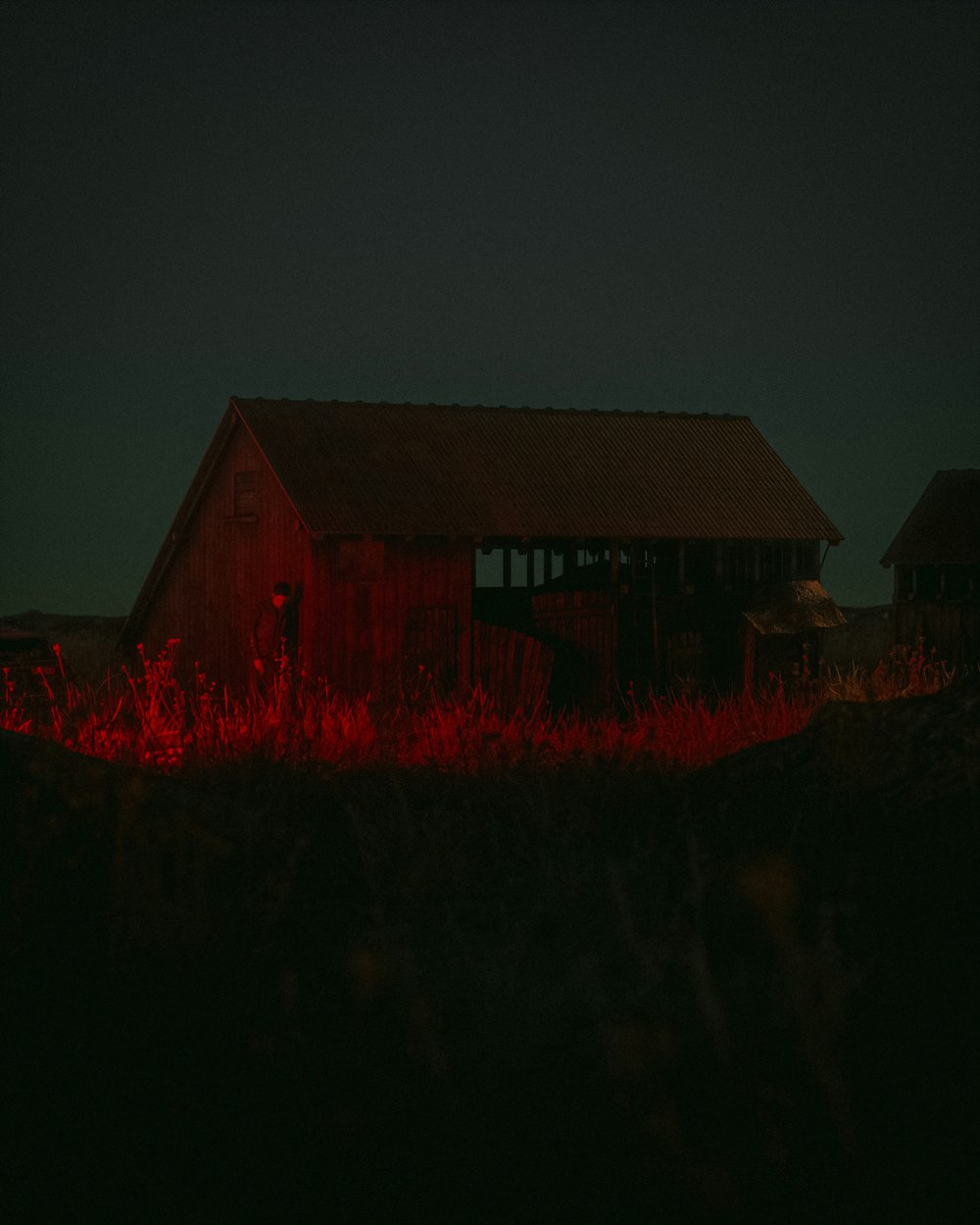 Un granero en medio de un campo por la noche