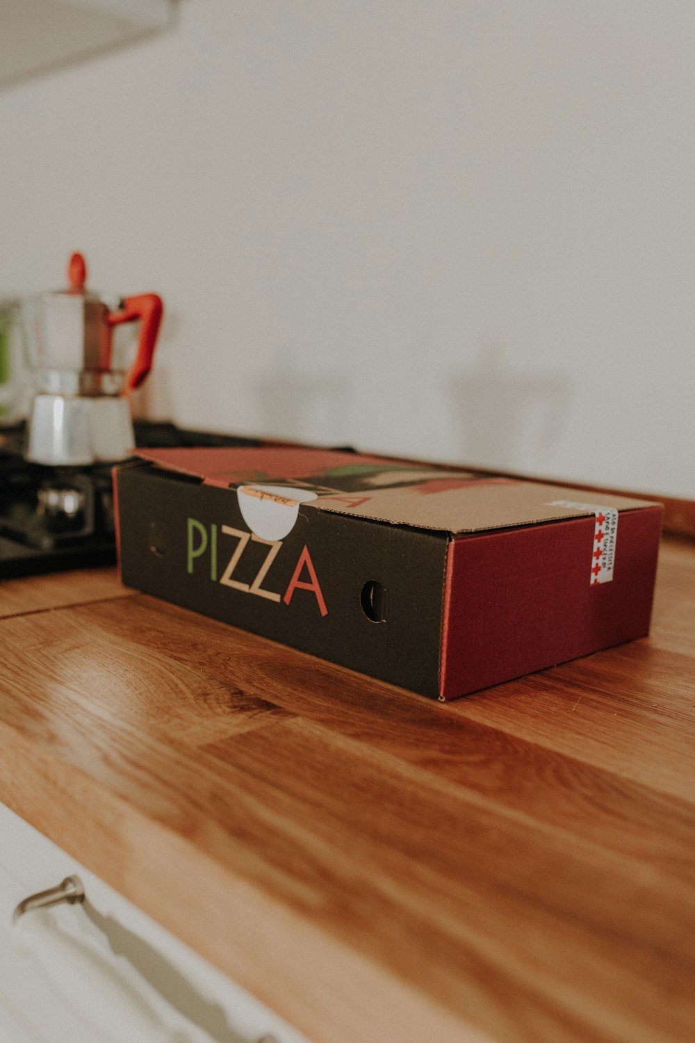 a pizza box sitting on top of a wooden counter