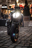 Motorcycle equipped with GPS tracker, shown on a city street at dusk.