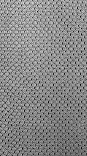 A close-up view of a textured fabric pattern featuring interlocking loops creating a mesh-like effect. The material appears to be knitted or woven with a consistent, repetitive design.