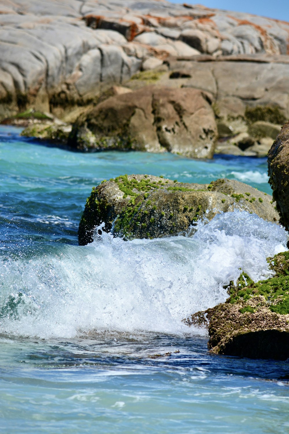 a body of water with rocks in the background