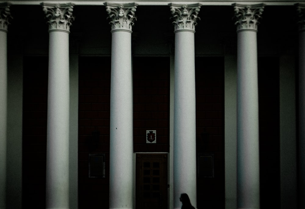 a person standing in front of a building with columns