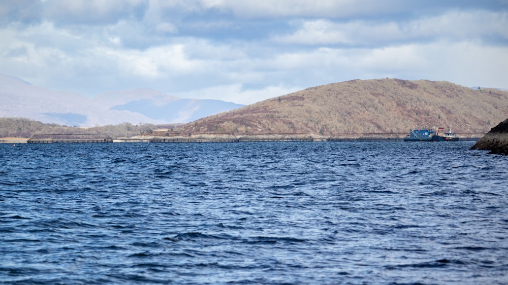 a large body of water with mountains in the background