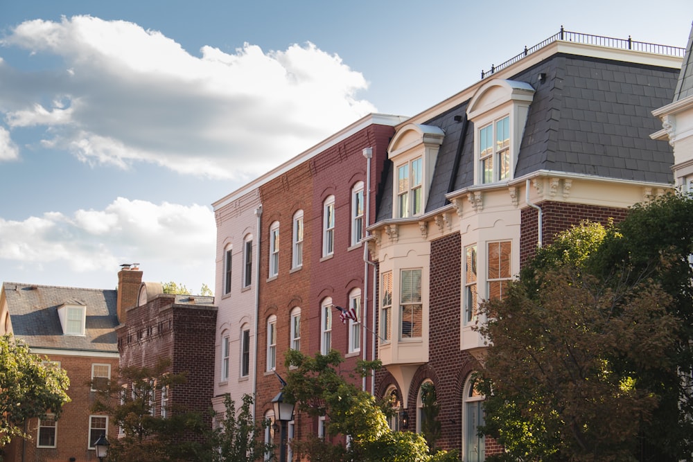 a row of brick buildings with trees in front of them