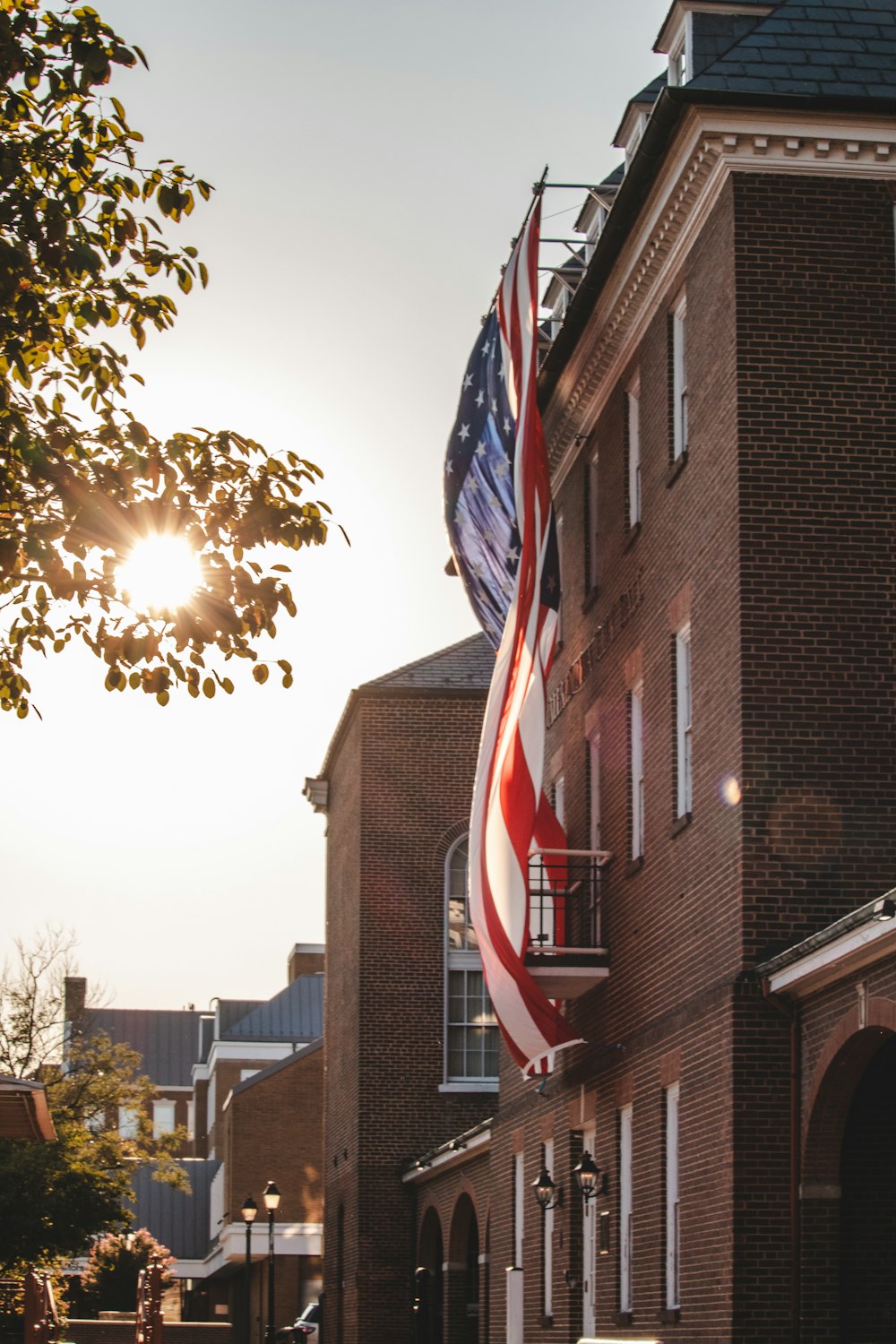 a large american flag hanging from the side of a building