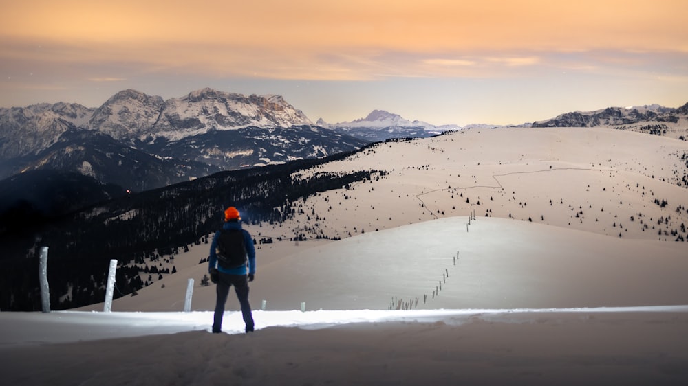 a man standing on top of a snow covered slope