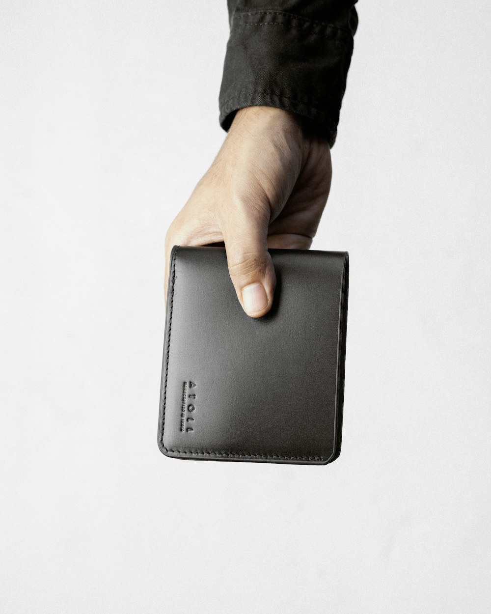 a hand holding a black leather wallet