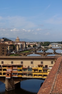 a bridge over a river with buildings in the background