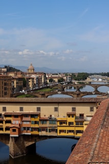 a bridge over a river with buildings in the background