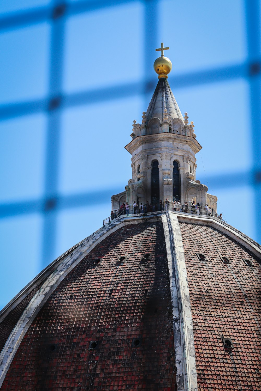 a view of the top of a building through a fence